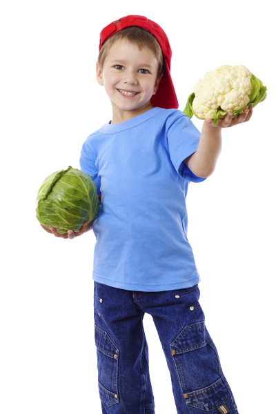 A child holding some vegetables